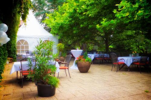 a patio with tables and chairs and a white tent at Landhaus Klosterwald in Lich