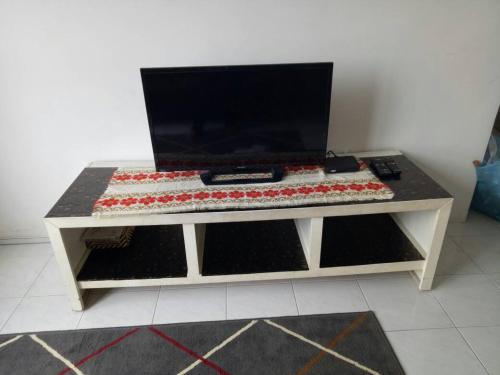 a table with a television on top of it at Affordable Stay @ Rue’s Villa Tropika Apartment, UKM Bangi in Bangi