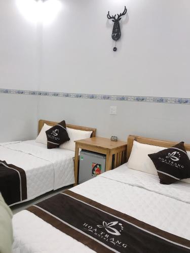 a room with two beds and a camera on the wall at Hoa Trang Hotel in Tuy An
