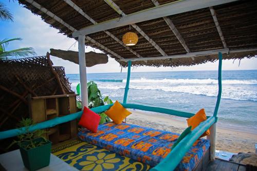 a porch with a swing on the beach at Brother's Beach Home in Galle