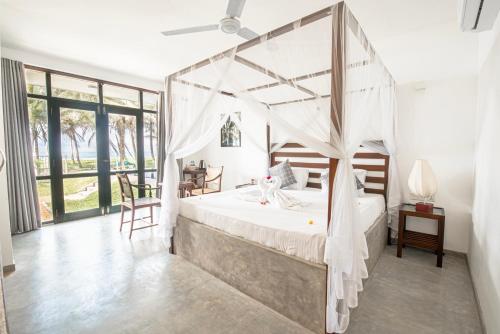 a bedroom with a bed with a canopy at Villa Nilnara in Ahungalla