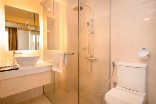 a bathroom with a shower and a toilet and a sink at Royce Hotel Kuala Lumpur Sentral in Kuala Lumpur