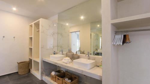 un bagno con due lavandini e un grande specchio di Mahasari Villa a Seminyak