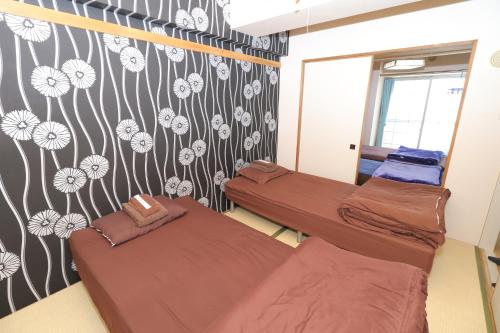two beds in a room with flowers on the wall at 札幌市中心部大通公園まで徒歩十分観光移動に便利なロケーションh202 in Sapporo