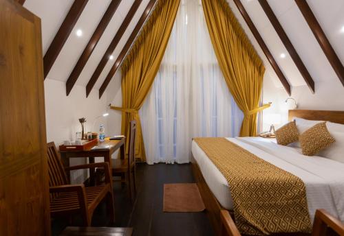 a bedroom with a bed and a table and a desk at Orchid Villa Kandy in Kandy