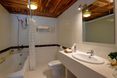 a bathroom with a sink and a tub and a toilet at Pakse hotel & Restaurant in Pakse