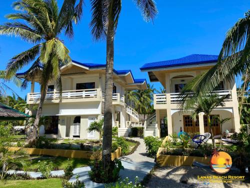 een huis met palmbomen ervoor bij Lanas Beach Resort in San Jose