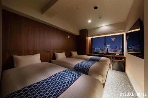 HOTEL AMANEK Asakusa Ekimae في طوكيو: غرفة فندقية بسريرين ونافذة كبيرة
