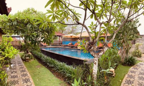 una piscina en medio de un jardín en The Akah Cottage - CHSE Certified, en Nusa Lembongan