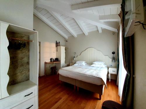 una camera con letto bianco e pavimento in legno di Hôtel Eze Hermitage entre Nice et Monaco a Èze