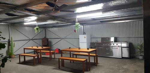 a kitchen with two tables and a stove at Bidgee Motor Inn in Hay