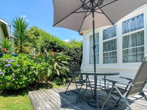 a table and chairs with an umbrella on a patio at Bavaria Boutique Hotel in Auckland