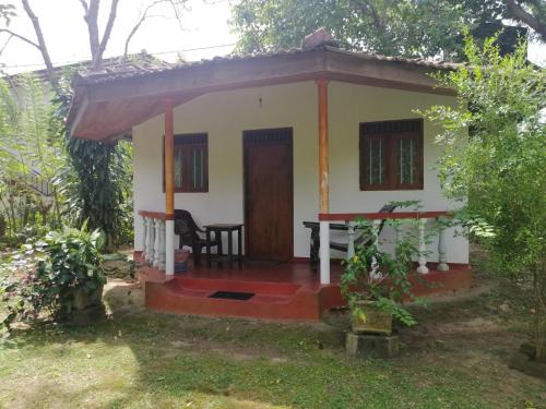 a small house with a table in the yard at Calm Garden Cabanas in Tangalle