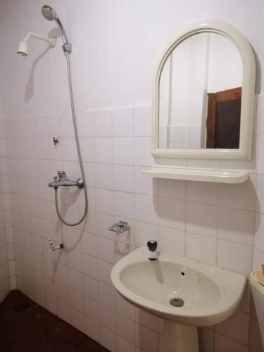 a white bathroom with a sink and a mirror at Calm Garden Cabanas in Tangalle
