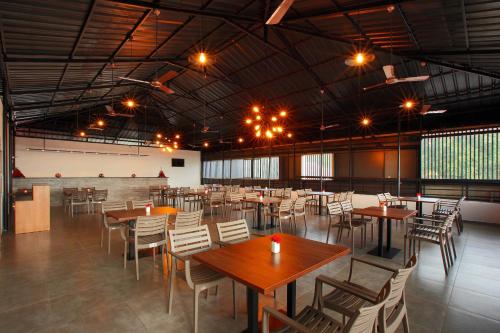 a large room with tables and chairs in it at Hotel Samrat in Taliparamba