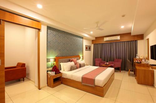 a hotel room with a bed and a desk at Hotel Samrat in Taliparamba