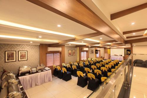 a banquet hall with tables and chairs in a room at Hotel Samrat in Taliparamba