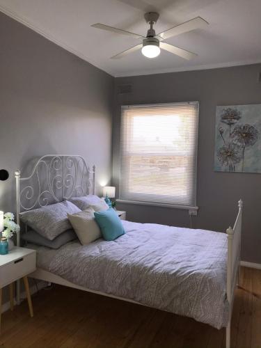 a bedroom with a bed with a ceiling fan at Cute and Cosy II - Events, Workers, Getaways. in Murray Bridge