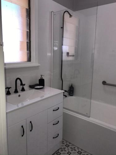 a white bathroom with a sink and a shower at Cute and Cosy II - Events, Workers, Getaways. in Murray Bridge