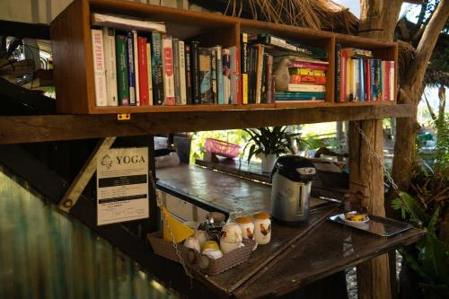 una estantería con libros y huevos sobre una mesa en Chilling Hill Guesthouse, en Pai