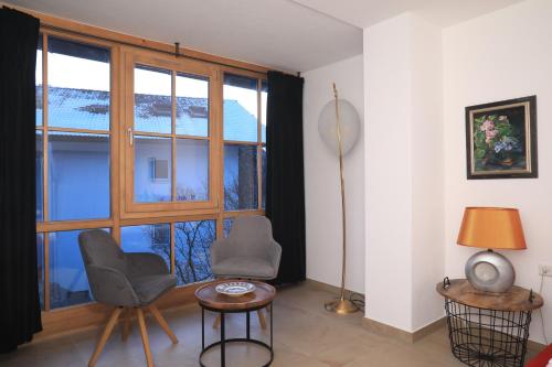 a living room with two chairs and a large window at Haus Luna - Apartments in Schwangau