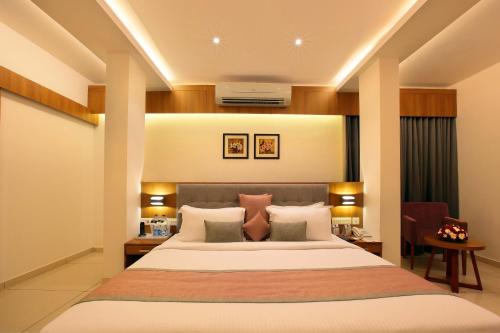 a bedroom with a large bed in a room at Hotel Samrat in Taliparamba