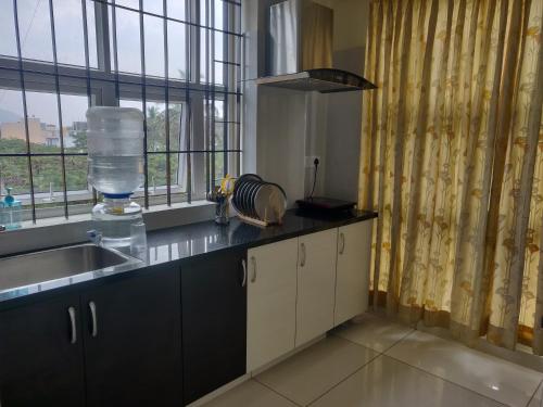 a kitchen with a sink and a counter with a window at Suvarna Compact in Mysore