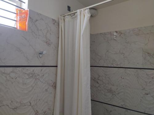 a bathroom with a shower with a shower curtain at Suvarna Compact in Mysore