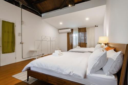 1 dormitorio con 1 cama blanca grande con almohadas blancas en Hearty Cottage en Hualien