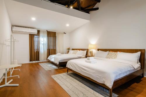 a bedroom with two beds and a table in it at Hearty Cottage in Hualien City