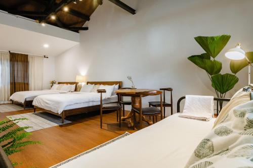 a bedroom with two beds and a table at Hearty Cottage in Hualien City