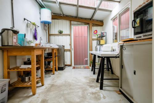 a kitchen with a table and a pink door at Hearty Cottage in Hualien City