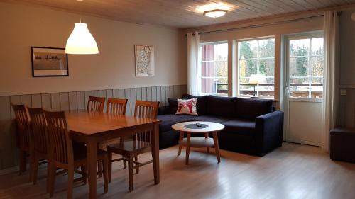 a living room with a table and a couch at Bjursås Berg & Sjö in Bjursås