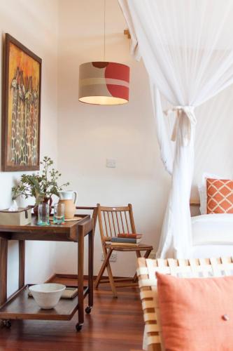 a room with a table and a bed and a table with a chair at Ololo Safari Lodge & Farm in Nairobi