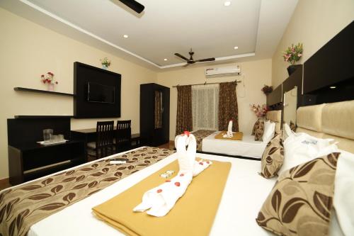 Cette chambre comprend 2 lits et une télévision. dans l'établissement Hotel Ragavendra Rameswaram, à Rameswaram