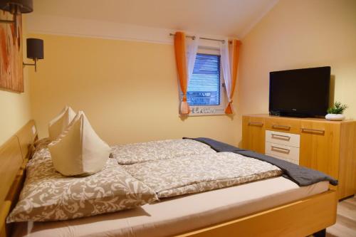 een slaapkamer met een bed en een flatscreen-tv bij Ferienwohnung Melanie in Kirchbach