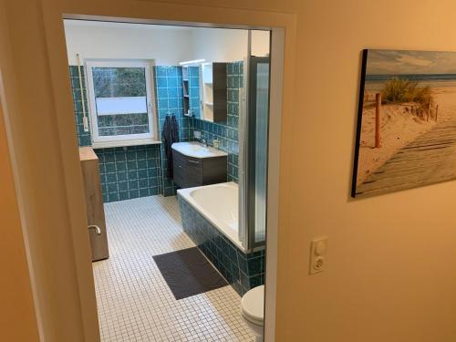 ein Badezimmer mit einer Badewanne, einem Waschbecken und einem WC in der Unterkunft Moderne Ferienwohnung nahe SWR und Golfplatz in Baden-Baden