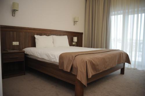 a bed in a room with a white bedspread at Porto Riva in Zaporozhye
