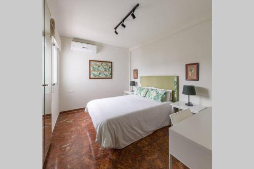 Dormitorio blanco con cama blanca y vestidor en Suite Alero, en Mairena del Aljarafe