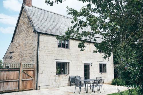 a table and chairs in front of a building at Rutland Water Courtyard Rooms in Oakham