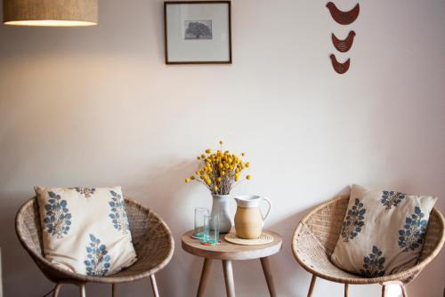 two chairs and a table with a vase on it at Ololo Safari Lodge & Farm in Nairobi