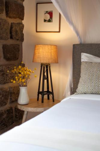 a bedroom with a bed and a table with a lamp at Ololo Safari Lodge & Farm in Nairobi