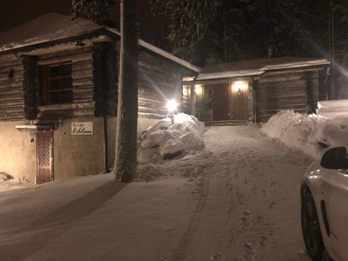 a house is covered in snow at night at Riihilinna Ski Lodge in Muurame