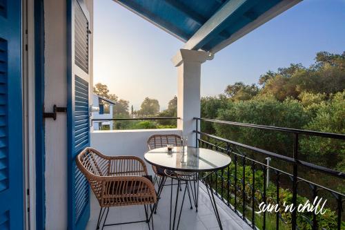 a patio with a table and chairs on a balcony at Sun 'n Chill, Boutique Apartments & Beach Villa in Melíkia