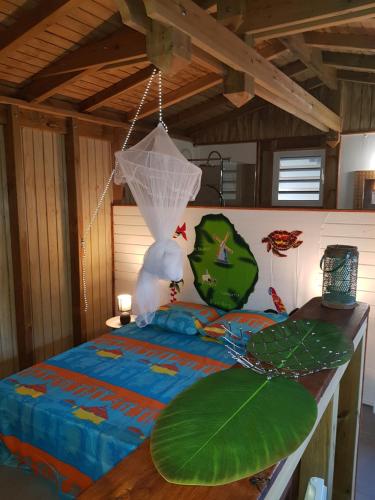 sypialnia z łóżkiem z siecią w obiekcie Cocktail Caraïbes, Résidence de Tourisme Meublée w mieście Saint-Louis