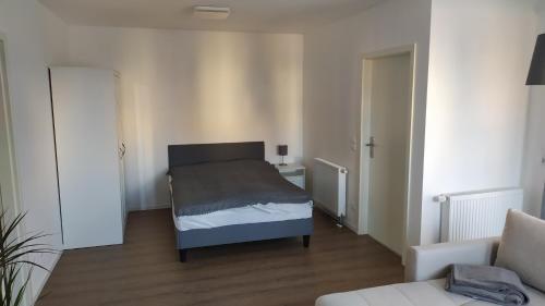 ein kleines Schlafzimmer mit einem Bett und einem Sofa in der Unterkunft 4* Ferienwohnung Neukirchen im Erzgebirge in Adorf