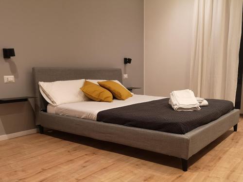 Una cama con dos almohadas amarillas encima. en ARMISI B&B en Catania