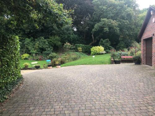 a brick driveway with a garden in the background at The Oaks in Warminster