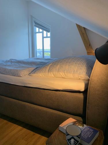 uma cama num quarto com uma janela e uma mesa em FeWo Herrmann em Petersdorf auf Fehmarn