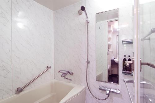 a bathroom with a tub and a shower and a sink at TsukubaNoYu Urban Hotel in Tsukuba